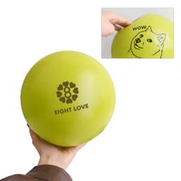 A hand holds a bright green inflatable PVC ball featuring a logo and whimsical designs.