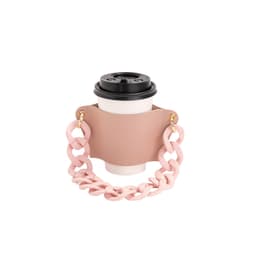 A drink bottle holder in pale pink with a chunky acrylic strap, featuring a coffee cup placed inside.