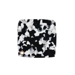 A square acetate vanity mirror featuring a black and white speckled design with a small gold accent.