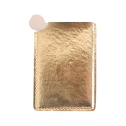 A gold portable mirror in a sleek, metallic case with a rounded edge and a small cutout for easy access.