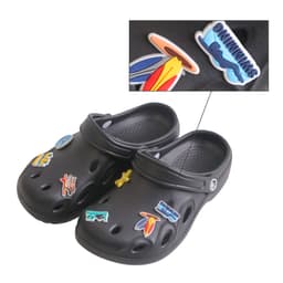 Black clog shoes adorned with colourful charms, featuring designs like surfboards and aquatic themes.