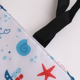 A large cooler tote bag in white featuring blue and red marine-themed designs, with black straps.