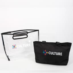 A black tote bag with handles next to a transparent PVC cover, both featuring a logo.