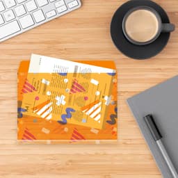 A rope-fastened folder in bright orange with a playful design, alongside a coffee cup, keyboard, and notebook.