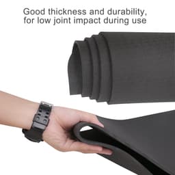 A premium TPE yoga mat in black, showcasing its thickness and durability, with a hand holding one edge.