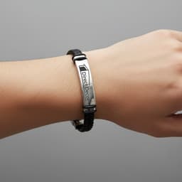 A black leather twine bracelet with a silver metal plate, featuring a logo. Worn on a person’s wrist.