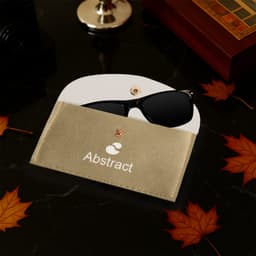 A gold PU leather glasses pouch with a white interior, holding a pair of black sunglasses. Features a logo.
