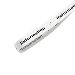 A white satin polyester ribbon with black text and a logo.