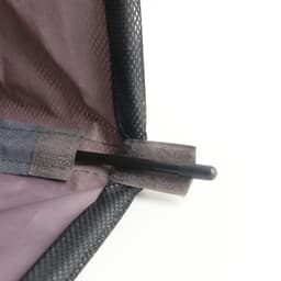 A close-up of a black laundry basket with wheels, featuring a mesh material and a pole secured in place.
