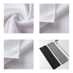 A waffle-textured golf towel in white, folded and displayed with a black and grey towel alongside. Features a branding logo.