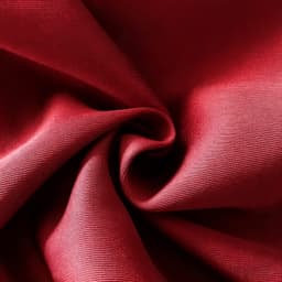 A close-up view of red polyester spandex fabric, showcasing its smooth texture and soft drape.