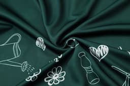 A close-up of dark green fabric featuring a pattern of white floral and gardening illustrations.