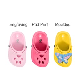 Three different paw-shaped clog shoe fridge magnets in pink and yellow, featuring moulded designs and engravings.