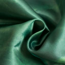 A green silk satin scarf with a smooth, lustrous texture, showcasing gentle folds and drapes.