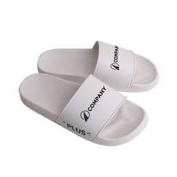 White PVC slides with a wide strap, featuring branding and a minimalist design.