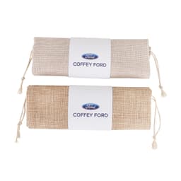 A small jute produce bag in natural and light brown colours, featuring a logo on a white label.