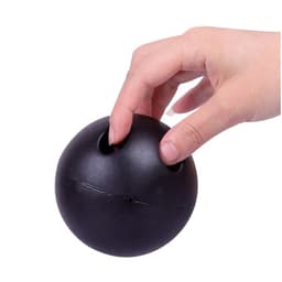 A black, bowling ball-shaped stress reliever with two finger holes is being held by a hand.
