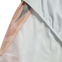 A close-up of breathable soccer shorts featuring a white and peach colour scheme, with a subtle mesh lining.