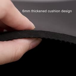 A hand holding the edge of a black yoga mat, highlighting its 6mm thick cushion design.