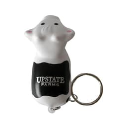 A keyring featuring a white cow stress reliever with a black section and a logo on it.