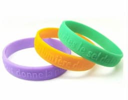 Three silicone wristbands in purple, orange, and green, featuring a logo and embossed text.