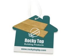 A house-shaped air freshener in teal and wood design, featuring a logo and a hanging string.