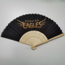 A black bamboo and fabric folding fan with a decorative design and a logo.