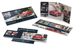 A promotional brochure featuring a red Mercedes-Benz E-Class, showcasing images and information about the vehicle.