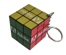 A Rubik's Cube keyring in green, yellow, red, and black with a branding logo.