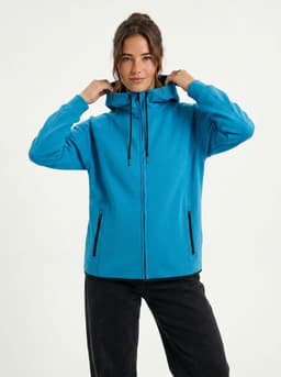 A woman wearing a blue soft cotton bonded polar fleece hoodie with a hood and zip front, featuring side pockets.