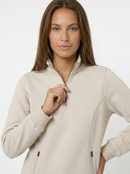 A women's half zip fleece jumper in a neutral beige colour, featuring a zippered collar and a fitted design.