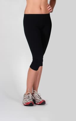 A pair of black 3/4 leg pants displayed on a model, paired with athletic shoes. The product has a logo.