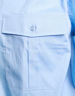 A light blue button-up shirt featuring an epaulette and a single front pocket with a button closure.