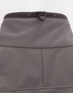 A grey ladies softshell hi-tech jacket featuring a high collar and adjustable cord at the neckline.