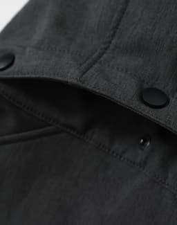 A men's softshell full zip hoodie in grey, featuring a hood and a logo on the inner collar.