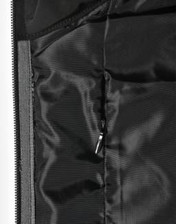 A close-up of a quilted jacket's interior lining in black, featuring a zippered pocket and smooth texture.