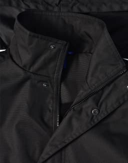 A black Long Line Stadium Jacket with a zip and snap closures, featuring a collar and logo branding.