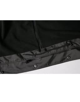 A black Long Line Stadium Jacket featuring a zippered pocket and snap fasteners at the hem. It has branding elements.