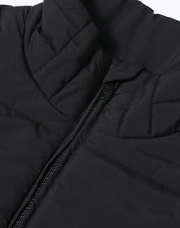 A black sustainable insulated puffer vest with a 3D cut and a zippered closure, featuring a logo.