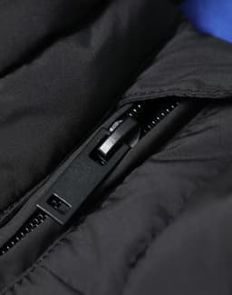 A black insulated puffer vest featuring a zippered opening and a smooth outer texture. It has a logo on the fabric.