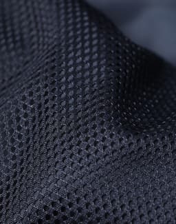 A close-up of textured black mesh fabric featuring a breathable design and a subtle sheen.