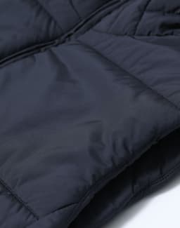 A navy blue sustainable insulated puffer vest with a 3D cut, featuring a quilted texture and a logo.