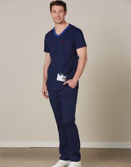 A navy short-sleeve scrub top with a contrast pocket, featuring a logo, paired with matching trousers.