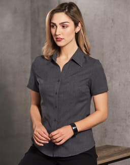A women's short sleeve shirt in dark grey with a button-up front and collar, featuring a logo.