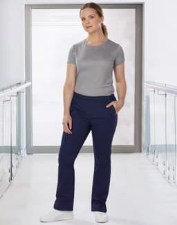 Ladies' solid colour scrub pants in navy, worn with a grey top, featuring a logo on the top.