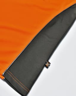An orange and grey polo shirt featuring a logo on the hem. The fabric is breathable and vented.