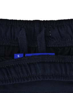 A close-up of navy blue sports shorts, featuring an interior waistband with adjustment tags and a logo.