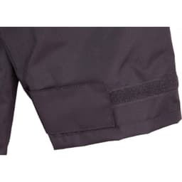 A close-up of a black safety jacket featuring a Velcro patch and reflective 3M tape accents.