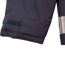 A dark navy safety jacket with reflective 3M tape and a velcro patch on the sleeve. Features branding.