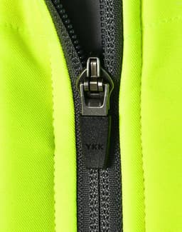 A close-up of a zip on a bright yellow safety jacket, featuring grey accents and a branded zipper pull.